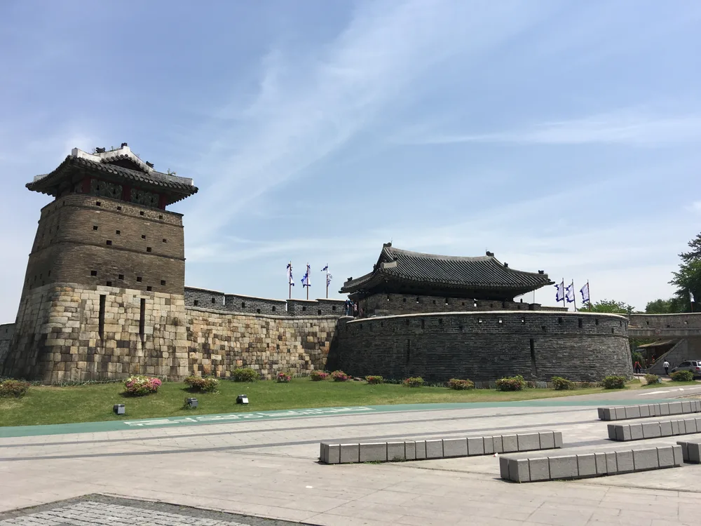 A stone watchtower and the semicircular barbican wall of Hwaseomun gate at Hwaseong Fortress