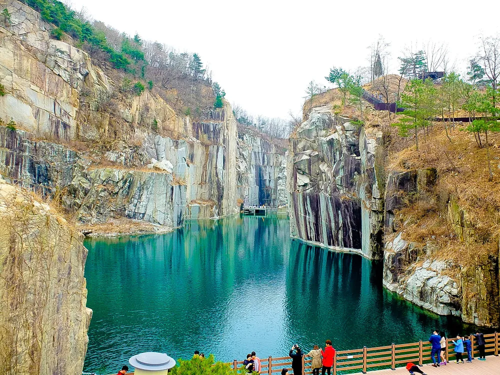 The deep green quarry lake at Pocheon Art Valley, ringed by sheer cut-granite cliffs