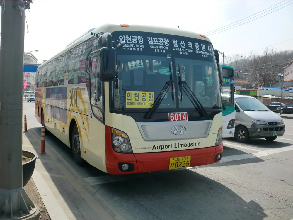 A cream-and-red Airport Limousine coach with an Incheon Airport destination sign