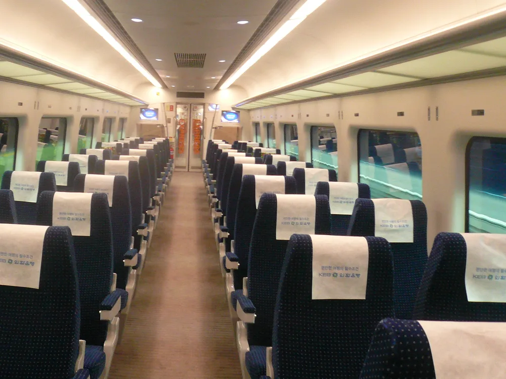 The interior of an AREX Express train — rows of 2+2 reserved seats with headrest covers and large windows
