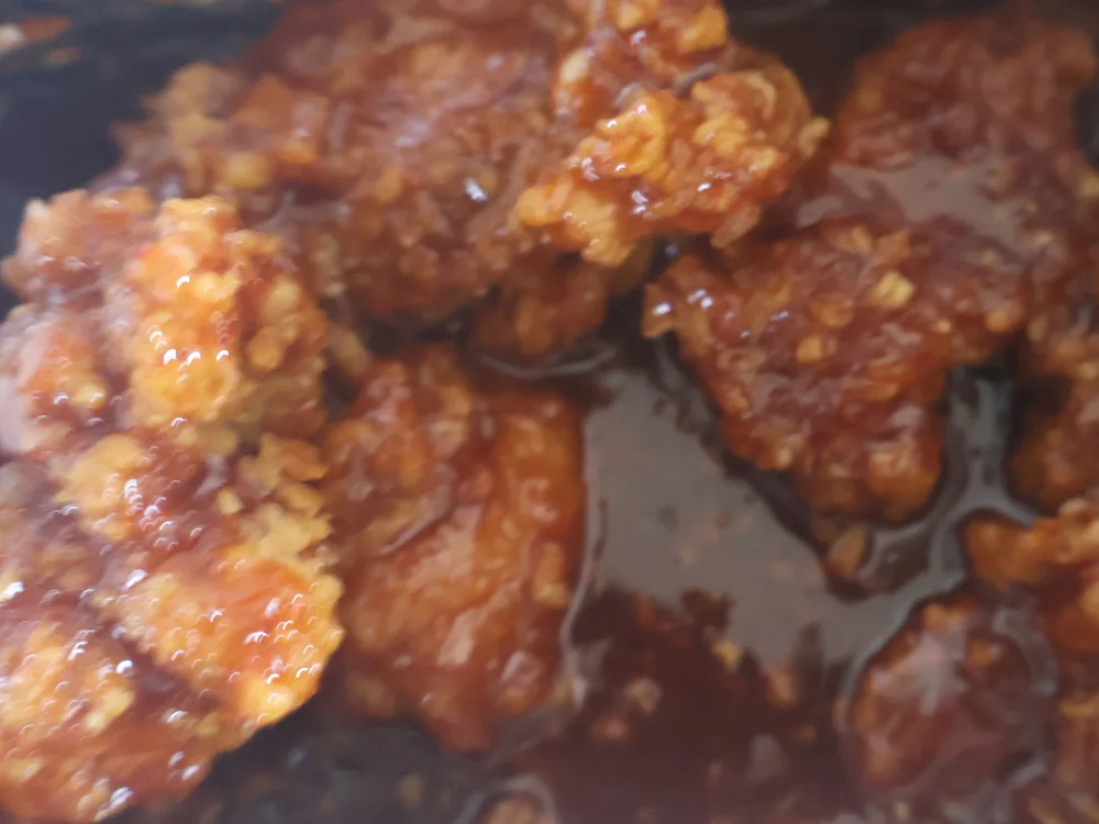Chicken pieces coated in a thick, glossy red-orange sweet-and-spicy yangnyeom glaze