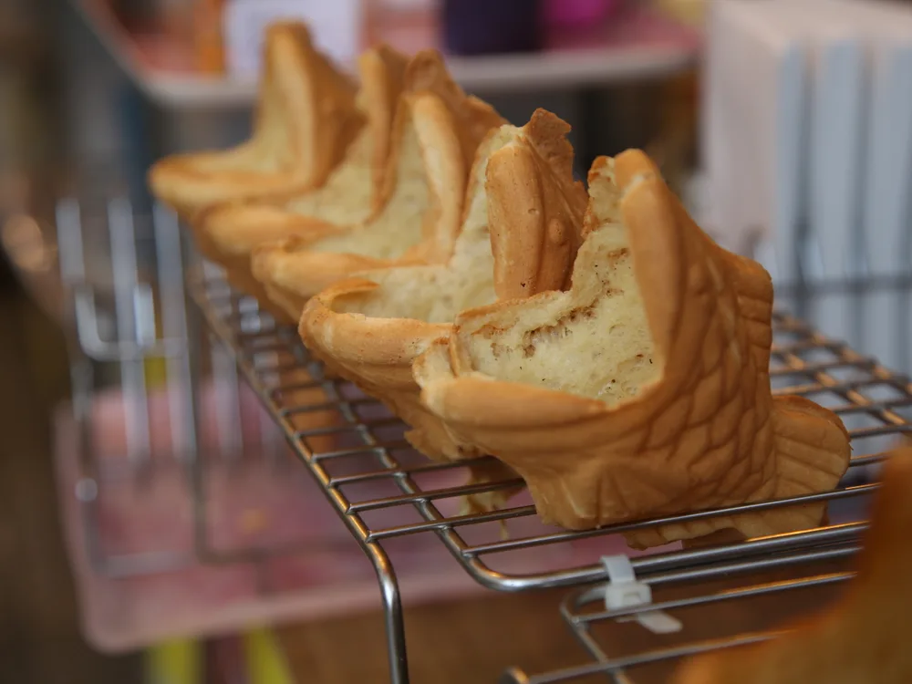 Fish-shaped bungeoppang pastries cooling on a wire rack, golden and split to show the crumb